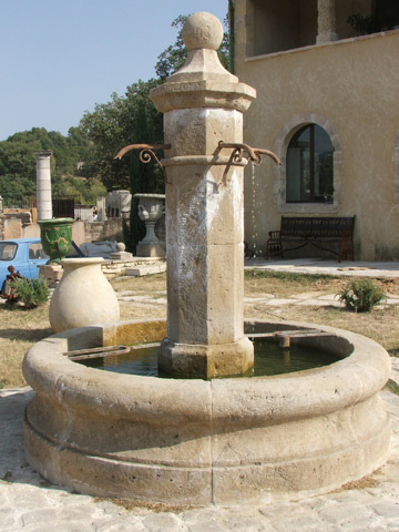 Fontaine centrale ronde en pierre neuve et vieillie